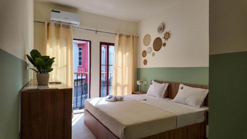 a bedroom with a bed in a room with a window at Urban Hostel Mindelo in Mindelo