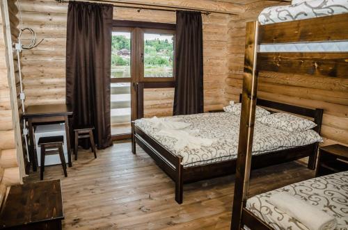 a bedroom with two bunk beds and a desk at Сонячна in Solotvyno