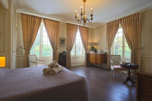 a bedroom with a teddy bear laying on a bed at Chambres d hôtes dans maison bourgeoise Douce France in Millau