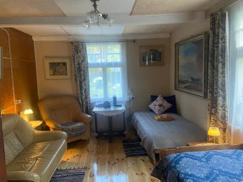 a living room with a couch and a bed and a window at Bezvējš in Jūrmala