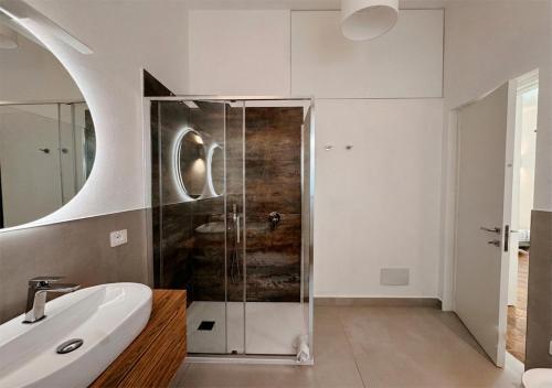 a bathroom with a glass shower and a sink at Isuleddu Room & Stairs in La Maddalena