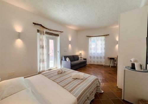 a bedroom with a large bed and a couch at Isuleddu Room & Stairs in La Maddalena