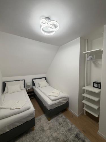a room with two beds and a light on the ceiling at Ady80 in Balatonmáriafürdő