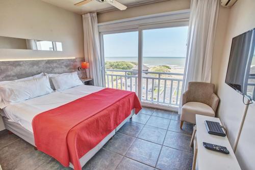 a bedroom with a bed and a view of the ocean at Torrecillas Carilo in Carilo