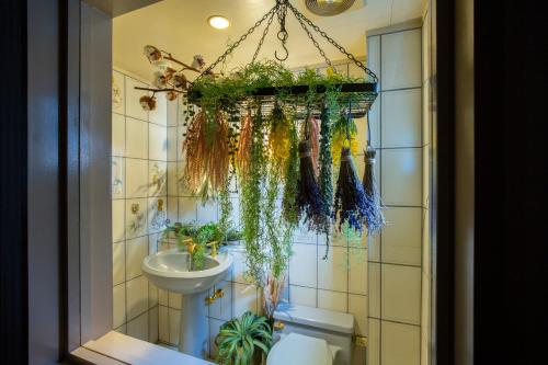 a bathroom with a toilet and a sink with plants at mahoratto in Aomori