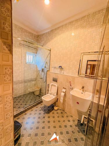 a bathroom with a toilet and a sink and a shower at Hols in Kaduna