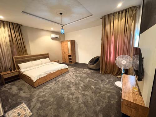 a bedroom with a bed and a fan in it at Hols in Kaduna
