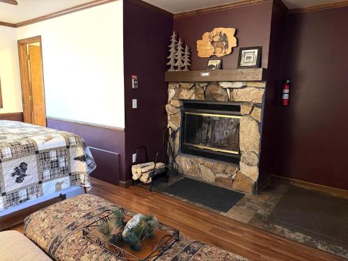 a bedroom with a stone fireplace in a room at Sunnyside Knoll- 3 studio in Estes Park