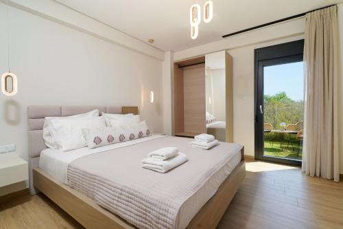 a bedroom with a large bed with towels on it at Ilias Suites in Skala Potamias