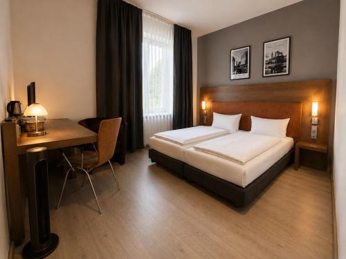 a hotel room with a bed and a desk at An der Stadthalle in Braunschweig