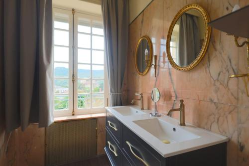 a bathroom with a sink and a mirror and a window at Chambres d hôtes dans maison bourgeoise Douce France in Millau