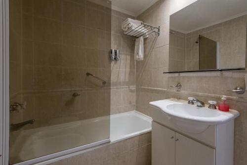 a bathroom with a sink and a shower and a tub at Torrecillas Carilo in Carilo