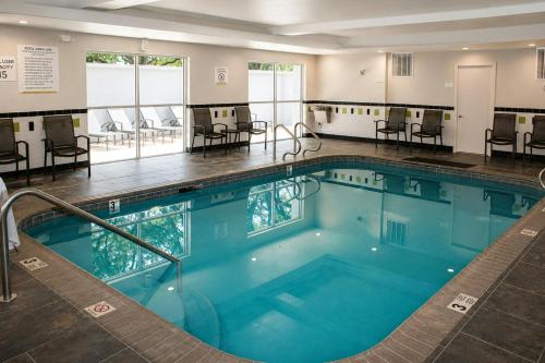 a large swimming pool with chairs and tables at City Express by Marriott Lafayette in Lafayette