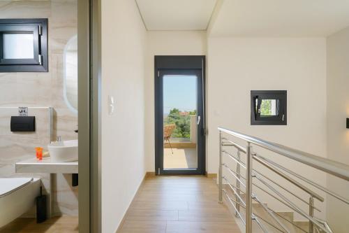 a bathroom with a hallway with a sink and a door at Ilias Suites in Skala Potamias