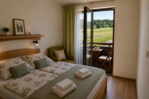 a bedroom with a bed and a balcony with a view at Apartmán PERLA 28 Říčky v Orlických horách in Říčky