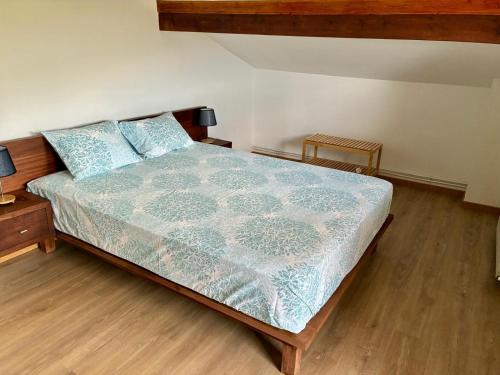 a bedroom with a bed with a blue comforter and two tables at Casa Vilariça in Alfândega da Fé