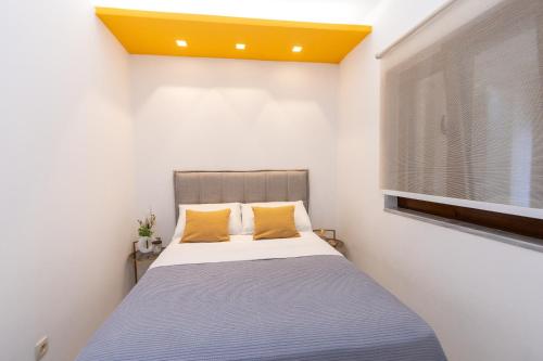 a bedroom with a bed with a yellow ceiling at Apartments Ardura in Petrovac na Moru