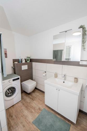 a bathroom with a sink and a washing machine at FeWo Seidenglanz in Dillenburg