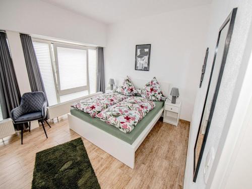 a bedroom with a bed and a chair and a window at FeWo Seidenglanz in Dillenburg
