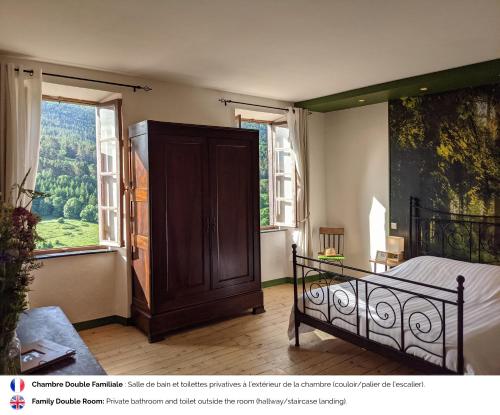 a bedroom with a bed and a large window at La Caminada Vielha in Montaillou