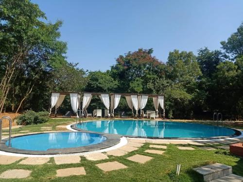 a swimming pool in the middle of a yard at Ananya Eco Resort in Surūrnagar