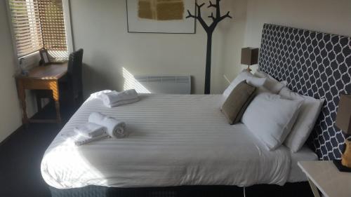 a bedroom with a large bed with white sheets and pillows at Fish Creek Hotel in Fish Creek