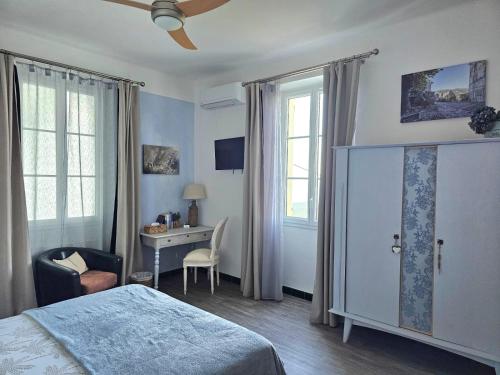 a bedroom with a bed and a desk and windows at Chambres d'hôte A Caserella, Maison de village rénovée avec vue sur mer in Valle-di-Campoloro