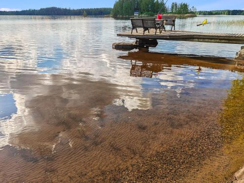 a bench sitting on a dock on a lake at Holiday Home Saarenpää by Interhome in Koivisto
