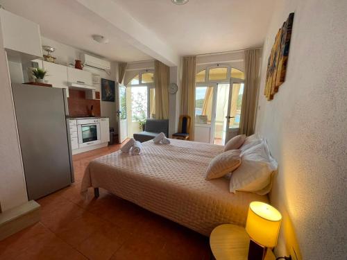 a bedroom with a large bed and a kitchen at Studio apartment Milna, Hvar Buratovic in Hvar