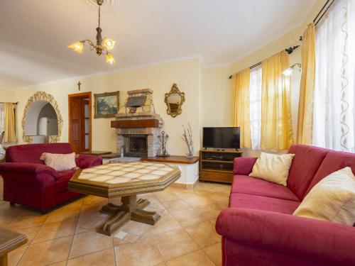 a living room with two red couches and a fireplace at Holiday Home Tamas by Interhome in Balatonőszöd