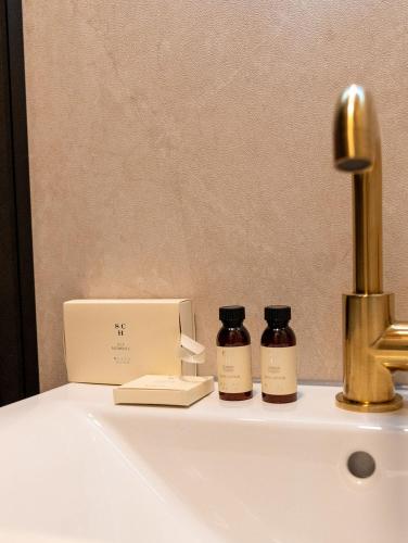 a bathroom sink with a faucet and two jars on it at Het Bakkershuus in Gramsbergen