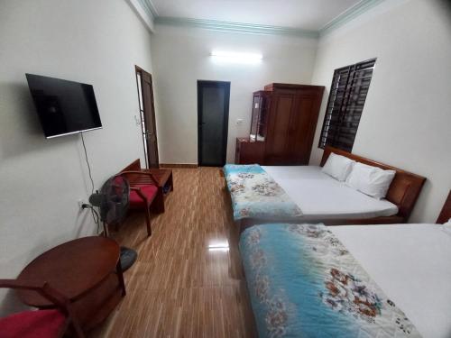 a hotel room with two beds and a television at Ovan New Beach Hotel in Dong Hoi