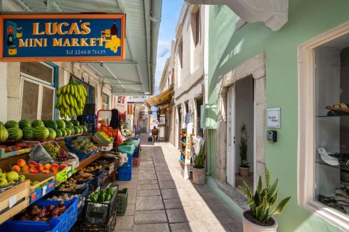 an alley in a market with fruits and vegetables at Symi Duo in Symi