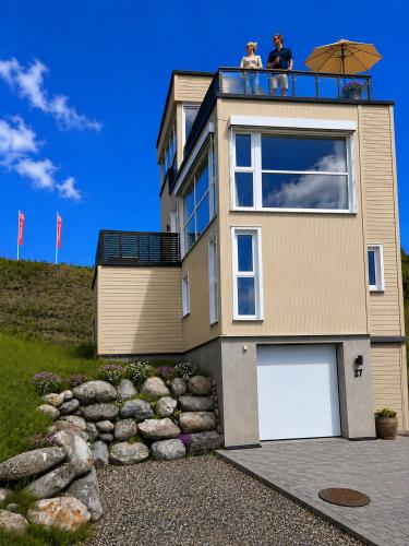 two people sitting on the balcony of a house at Eksklusiv hytte, Utsikt, ro og høy komfort in Gjøvik