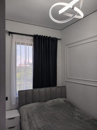 a bedroom with a bed with a ceiling fan and a window at MM House in Yerevan