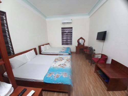 a bedroom with a bed and a desk and a television at Ovan New Beach Hotel in Dong Hoi
