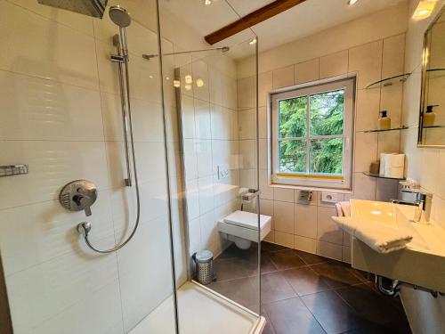 a bathroom with a shower and a toilet and a sink at Pension Bergheim in Tannheim