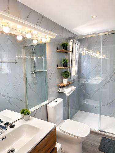 a bathroom with a toilet and a sink and a shower at Blue House Calafell in Calafell