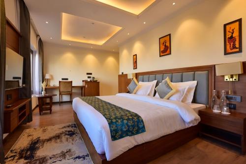 a bedroom with a large bed and a dining room at Hotel Aero Ladakh in Leh