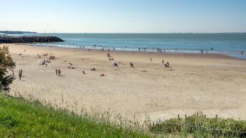 a group of people on a beach near the ocean at Kyriad - Royan Plage in Royan