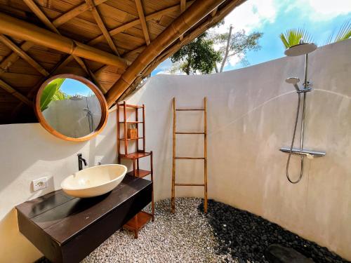 a bathroom with a sink and a mirror at Circle House Bamboo Sidemen in Silebeng
