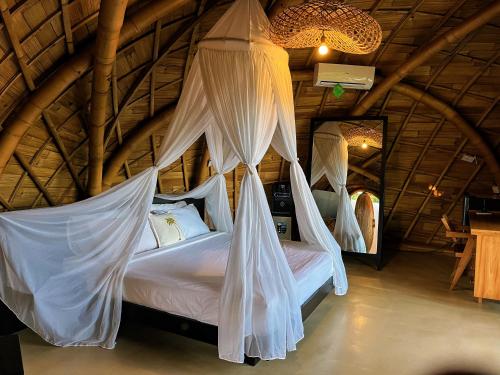 a bedroom with two beds with mosquito nets at Circle House Bamboo Sidemen in Silebeng