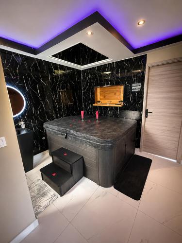 a jacuzzi tub in a room with a purple ceiling at Love room Coconut Secret in Le Gosier