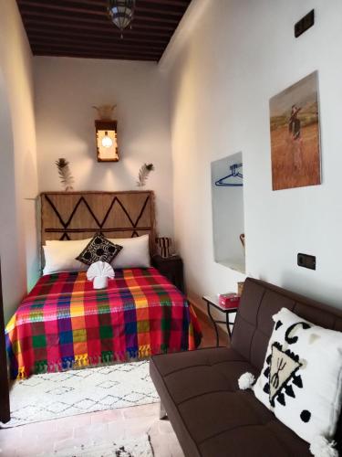 a bedroom with a bed and a couch at Riad la Fíbula de Nora in Fez