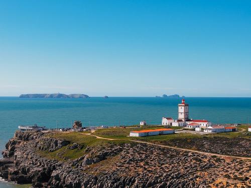 a lighthouse on a rocky island in the ocean at Sea Garden Peniche in Peniche