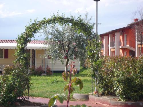 a garden with an arch in front of a building at The Garda Village in Sirmione