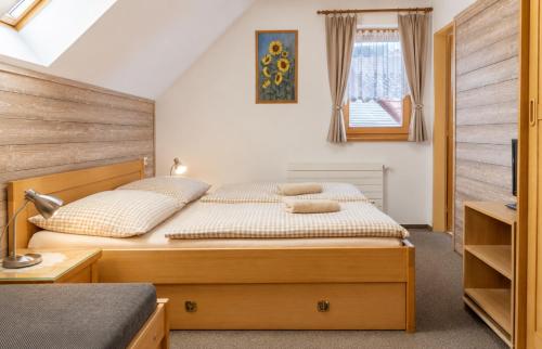 a bedroom with a bed and a window at Andrejkin dom in Blatnica
