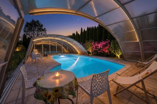 an indoor pool in a dome with chairs and a table at JD Apartamenty - Klimatyzacja, basen, parking i wifi w cenie in Mysłakowice