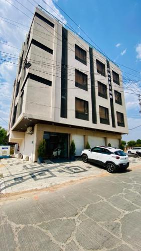 a white car parked in front of a building at Hotel Rove Inn in Indore