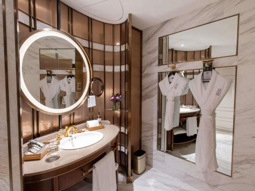 a bathroom with a sink and a mirror at Admiral Hotel Manila - MGallery Collection in Manila
